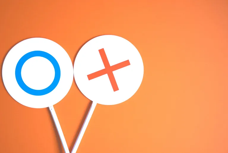 Handwimpel mit Kreis- und X-Zeichen auf orangenem Hintergrund.