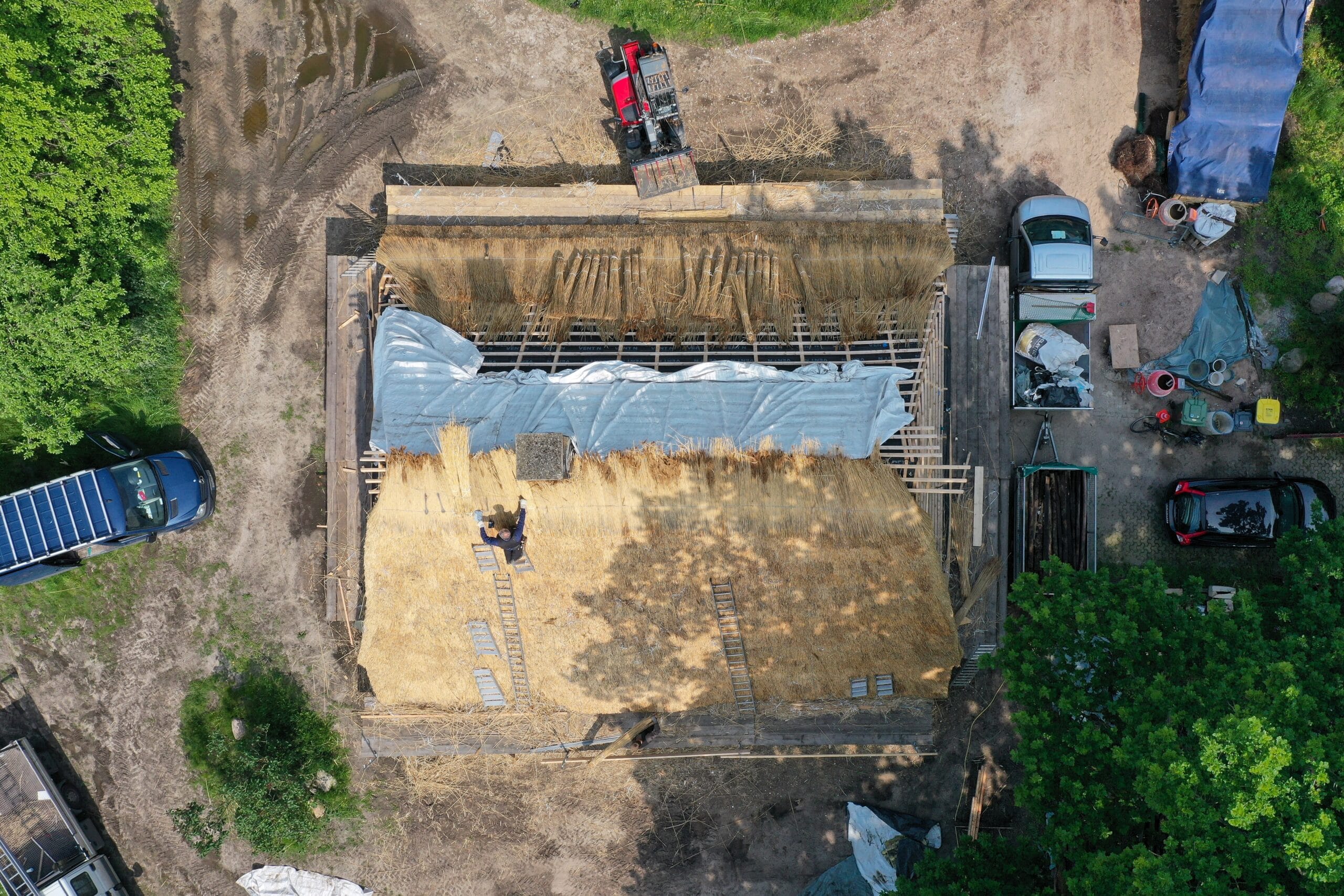 An einem Reetdach wird gearbeitet (Luftaufnahme mit einer Drohne).