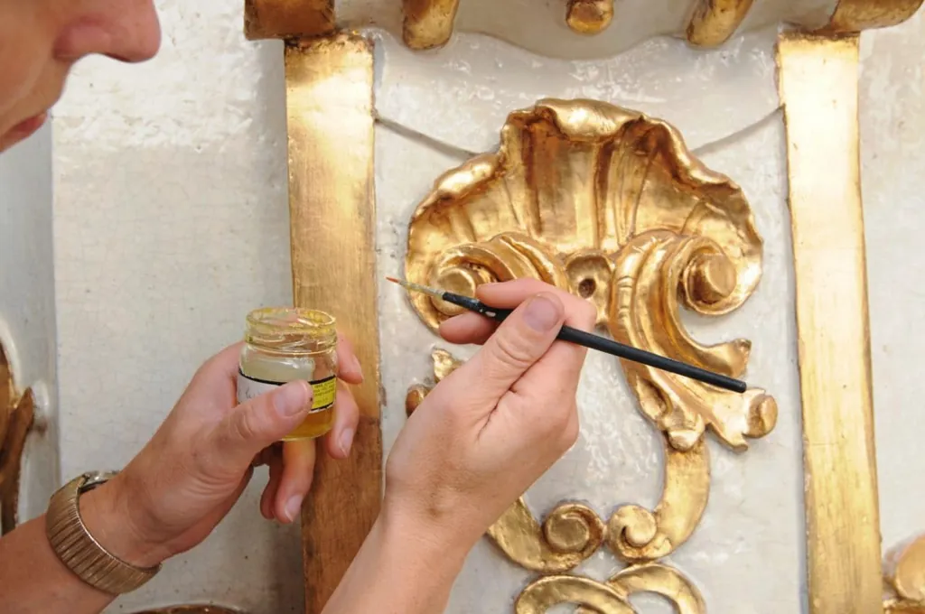 Restaurator beim vergolden von Stuck