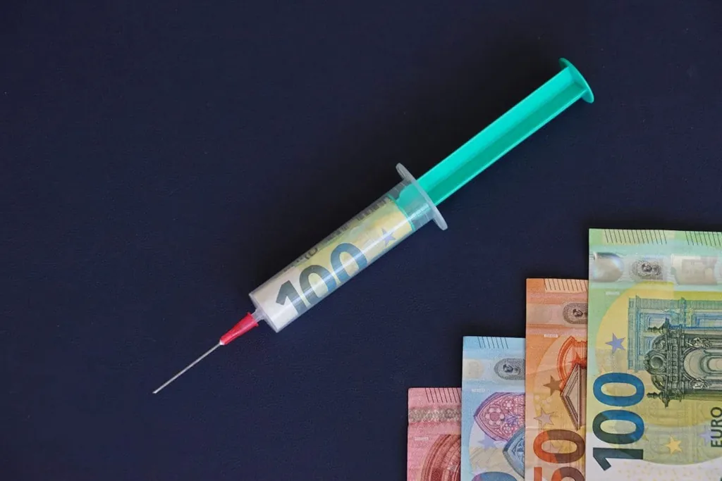 Spritze gef&uuml;llt mit gerolltem Geldschein