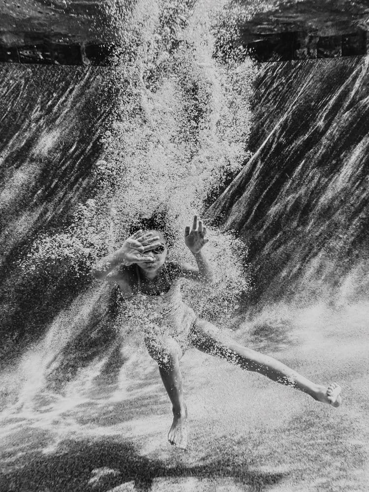 Unterwasseraufnahmen eines Mädchens beim Tauchen in einem Swimmingpool