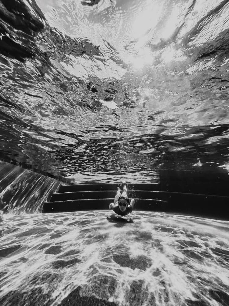 Unterwasseraufnahmen eines Mädchens beim Tauchen in einem Swimmingpool