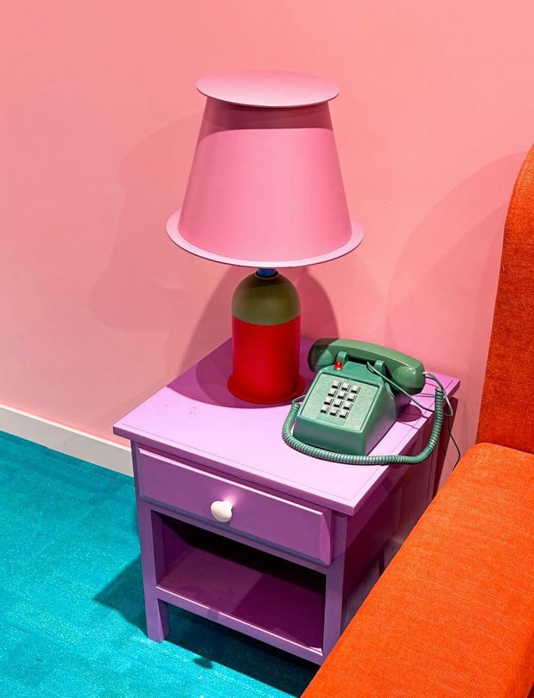 "Colour blocking" Nachttisch, Lampe, Bett, altes Telefon, Wand und Teppich