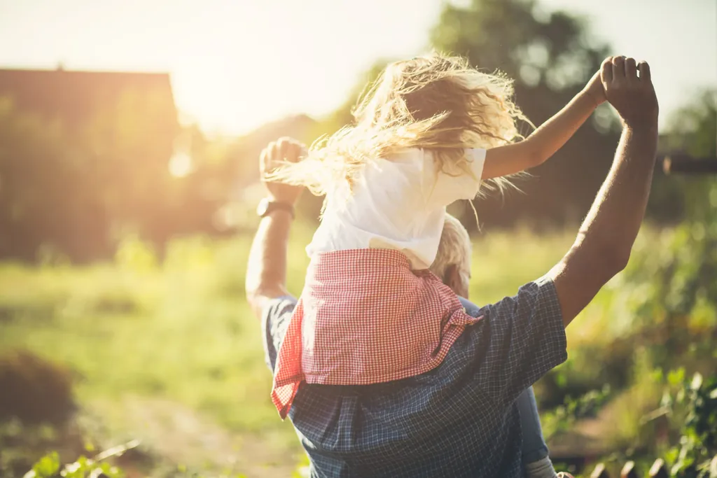 Mann tr&auml;gt kleines Kind auf den Schultern