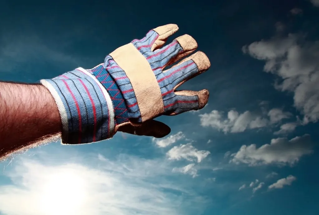 Hand in Arbeitshandschuh verdeckt die Sonne