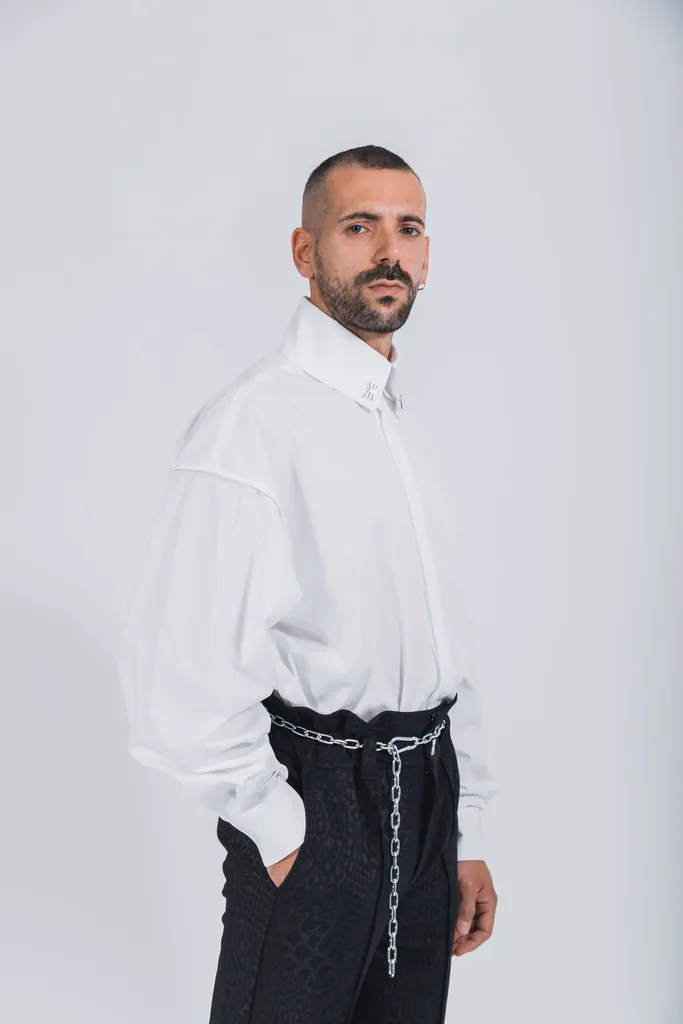 Model tr&auml;gt wei&szlig;es Hemd und schwarze Hose.