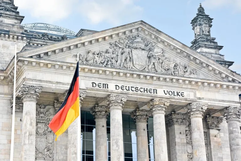 Der Reichstag mit der Deutschlandflagge im Vordergrund