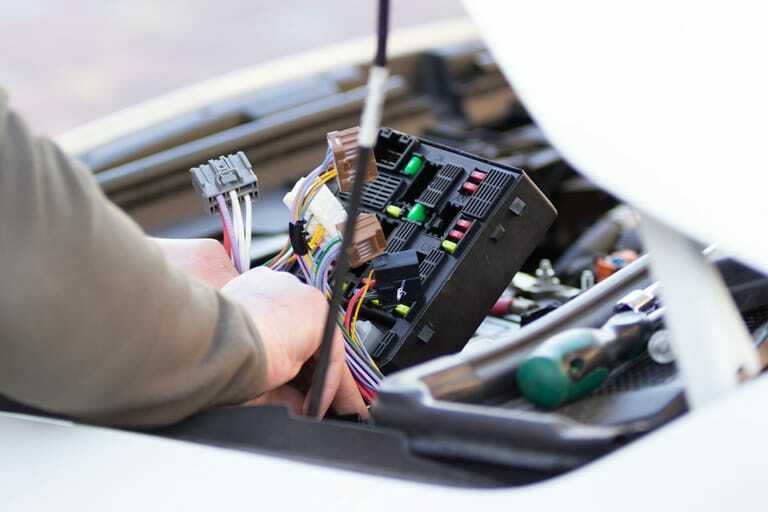 Mechaniker überprüft Autosicherung von Elektroauto.
