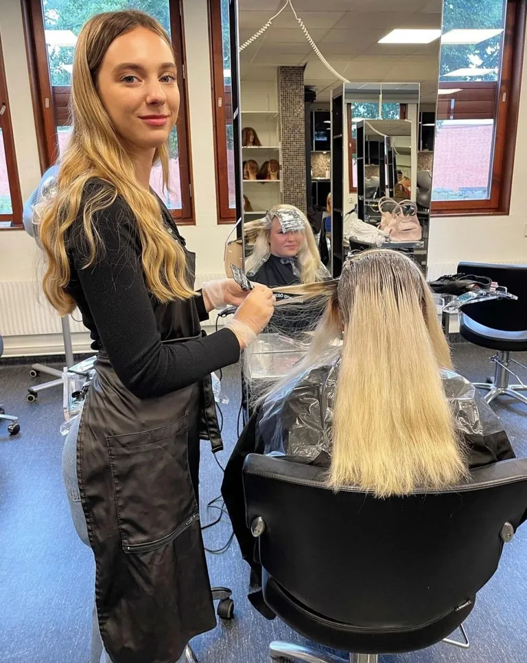 Friseurin f&auml;rbt Kundin die Haare