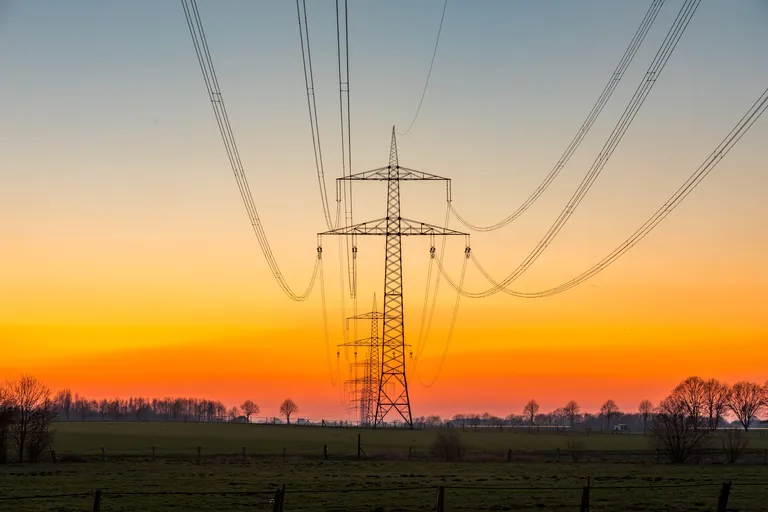 Eine Hochspannungsleitung im Sonnenuntergang, Deutschland.