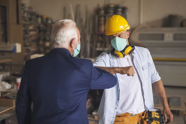Zwei M&auml;nner begr&uuml;&szlig;en sich mit dem Ellenbogen