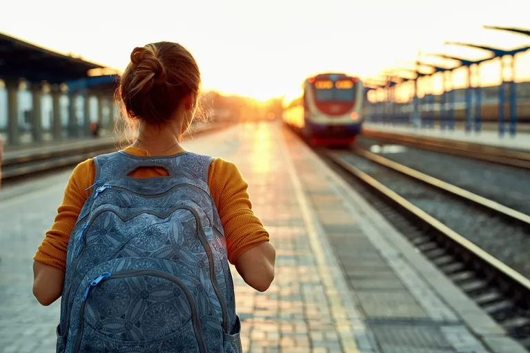 Eine junge Frau wartet auf den Zug.