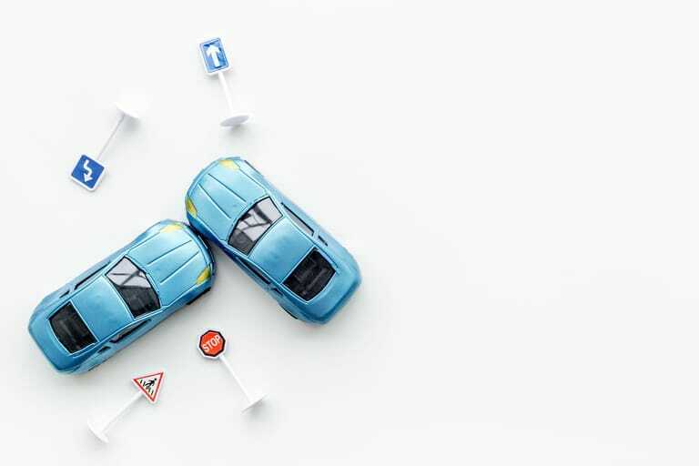 Zwei Spielzeugautos und -schilder auf weißem Hintergrund.