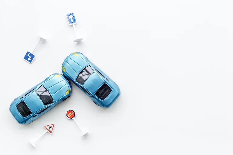 Zwei Spielzeugautos und -schilder auf wei&szlig;em Hintergrund.