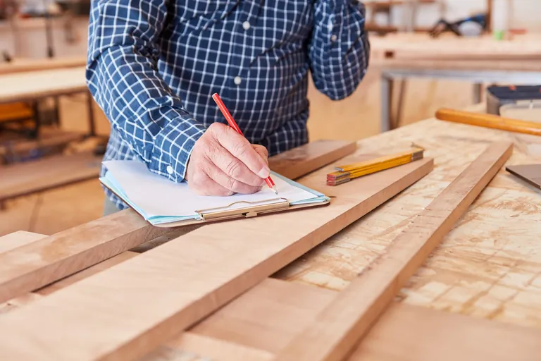 Handwerker mit Bleistift und Checkliste plant und organisiert einen Auftrag
