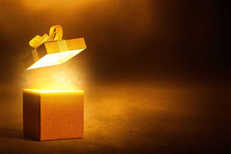 Goldene Geschenkbox vor schwarzem Hintergrund.