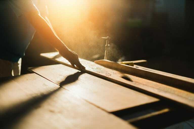 Tischler arbeitet mit Holz an Maschine.