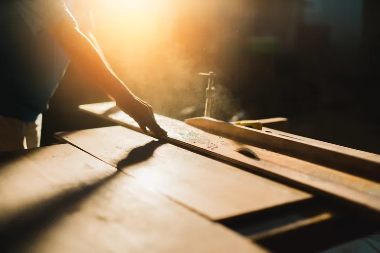 Tischler arbeitet mit Holz an Maschine.