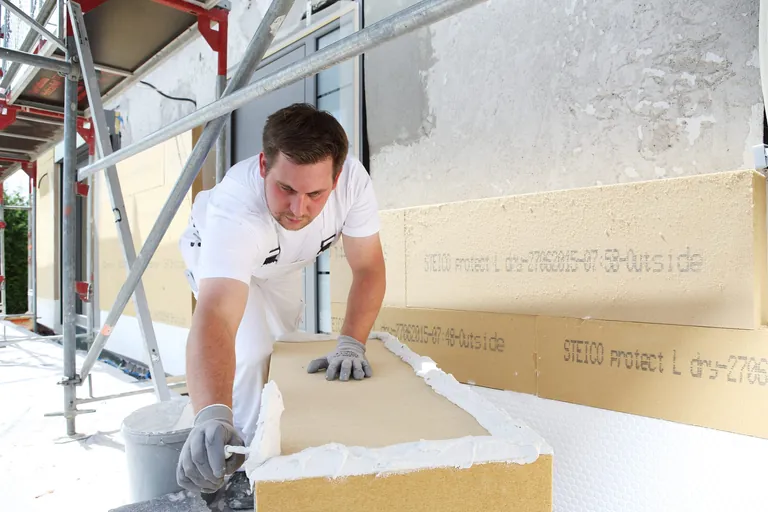 Handwerker bringt D&auml;mmung an