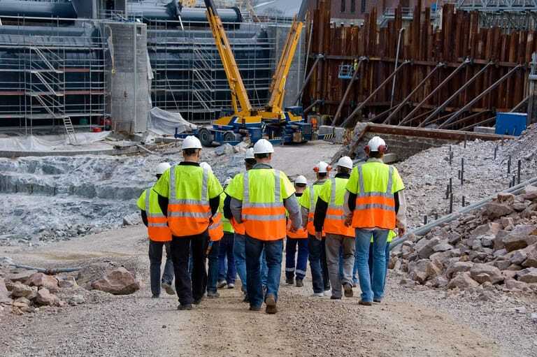Bauarbeiter auf Baustelle. R&uuml;ckenansicht.