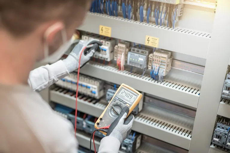 Elektriker testet Strom an elektrischer Schalttafel