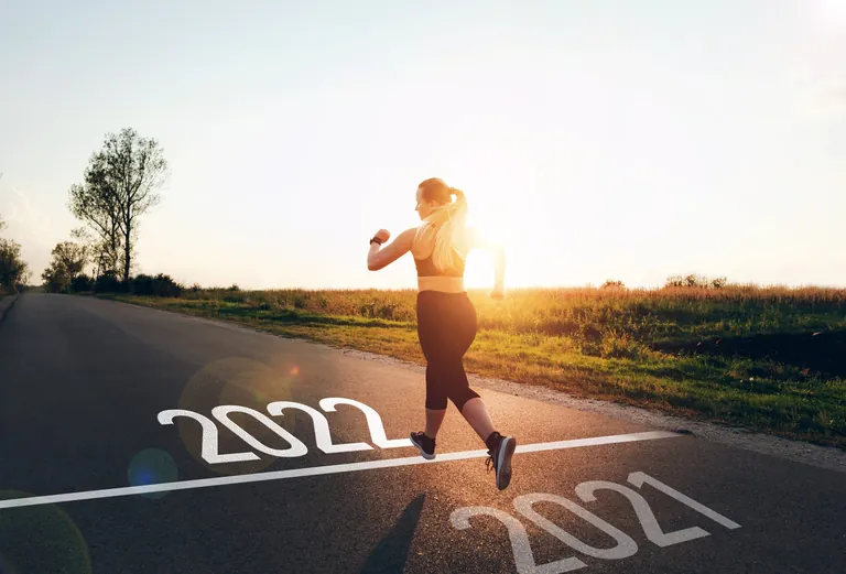 Joggerin rennt &uuml;ber Ziel-Linie mit Beschriftung 2021/2022.