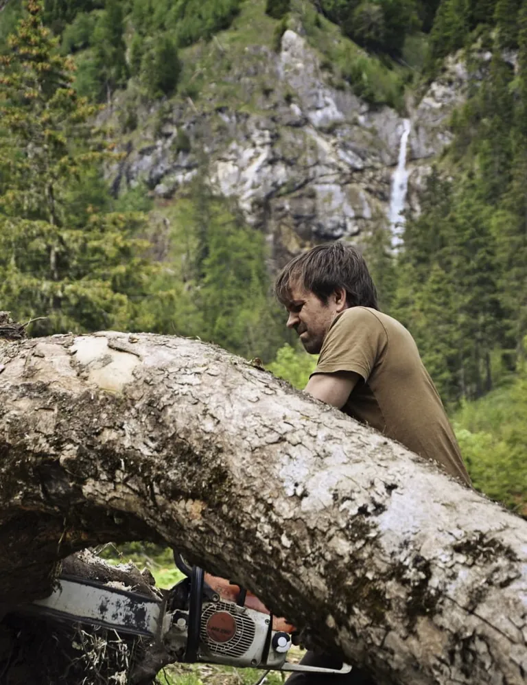 Christoph Finkel mit der Kettensäge im Gebirge.