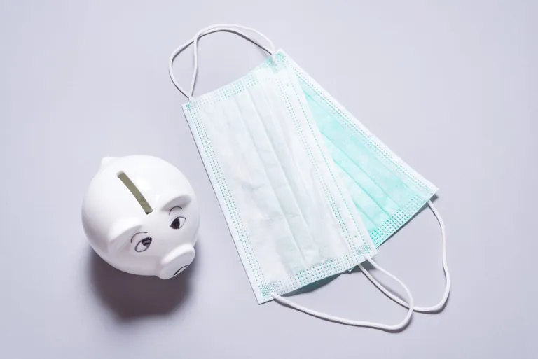 Sparschwein und Corona-Masken.