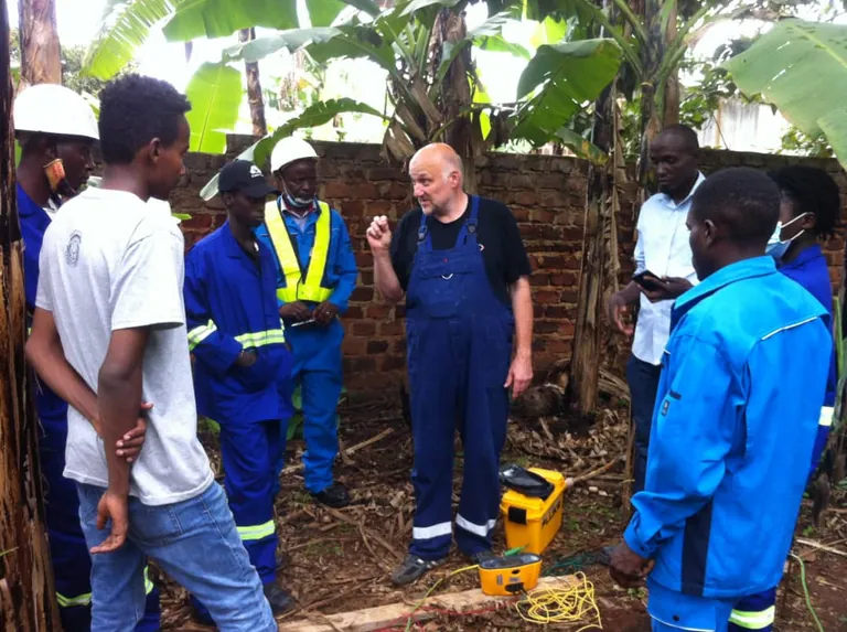 Handwerksmeister Manfred Becker schult Handwerker aus Ruanda, Erdung in der Bananenplantage.