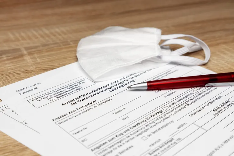 Antrag auf Kurzarbeitergeld mit wei&szlig;er Schutzmaske.