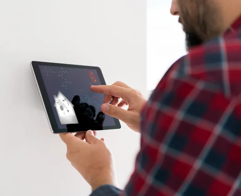 Mann tippt auf Tablet, Smart Home.