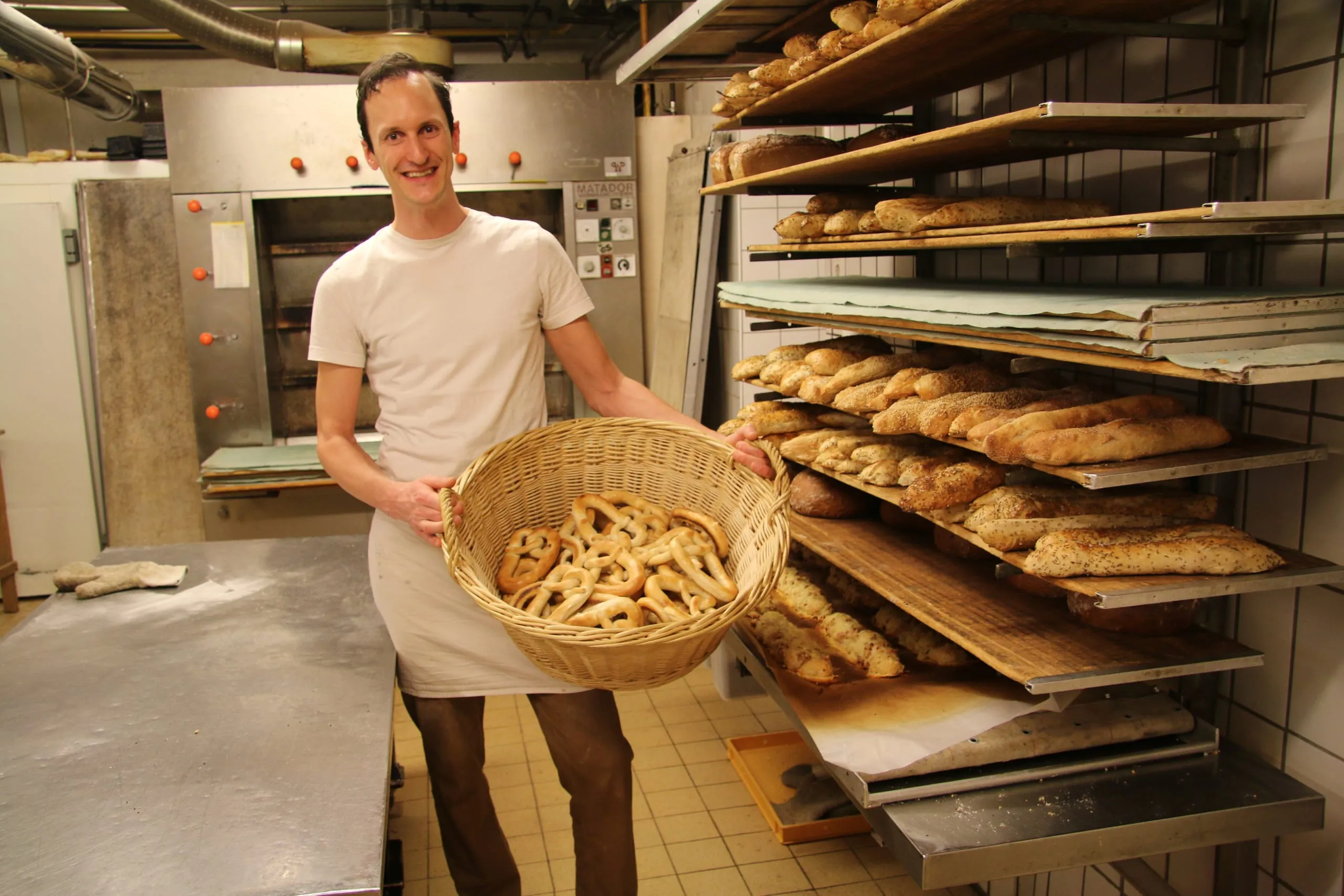 Bäckermeister Markus Häring in der Backstube mit einem Korb voll Fastenbrezeln