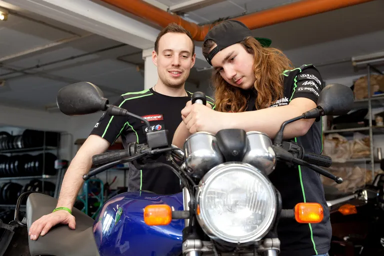 Zwei Auszubildende reparieren ein Motorrad