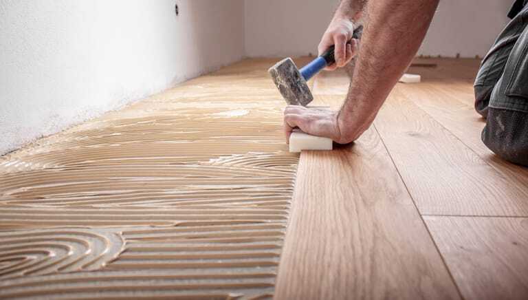 Bodenleger verlegt Parkett