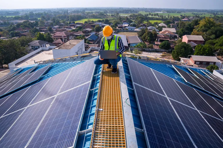 Solarmodule und Handwerker auf einem Hausdach