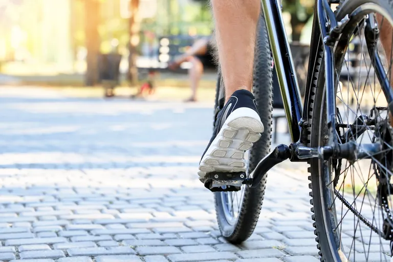 Radfahrer f&auml;hrt durch Stadt. Nahansicht.