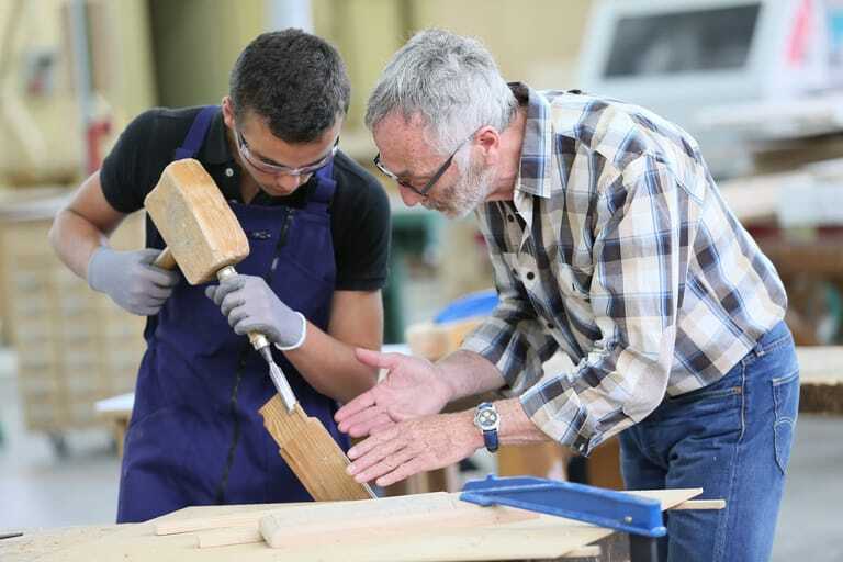 Handwerksmeister und Azubi