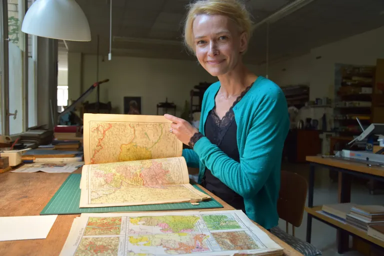 Buchbinderin mit altem Atlas