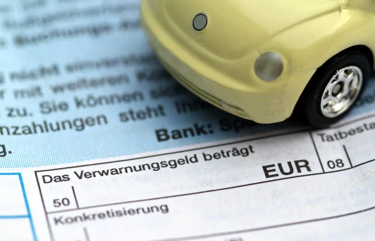 Strafzettel und Spielzeugauto.
