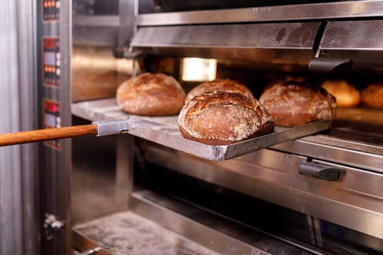 BÄcker holt Brot aus dem Ofen