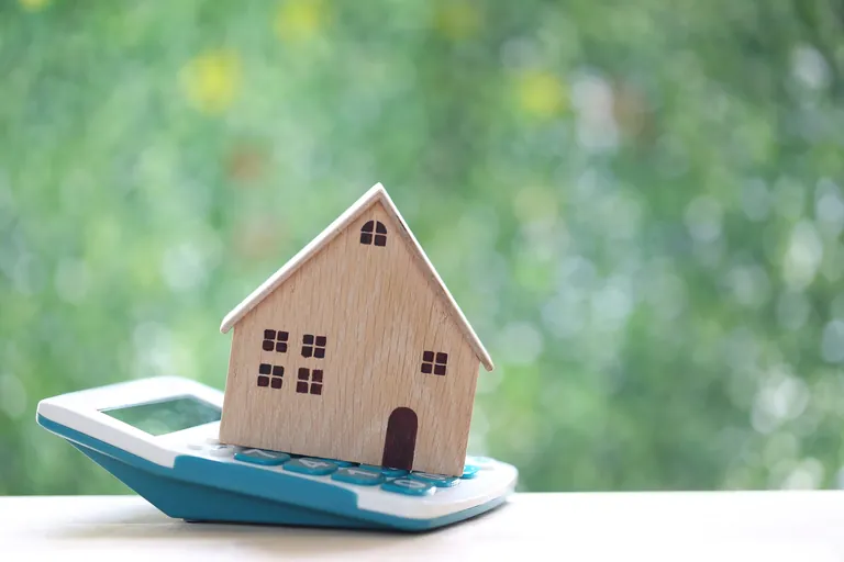 Miniatur-Holzhaus auf Taschenrechner.