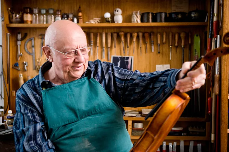 Geigenbauer mit Geige