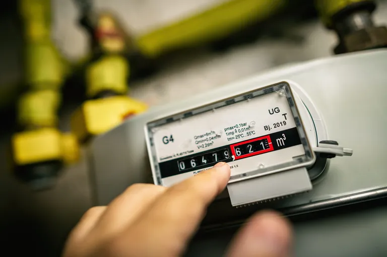 Finger zeigt auf Gasz&auml;hler mit Z&auml;hlerstand im Keller.