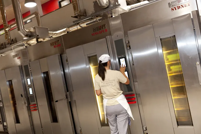 Bäckerin schiebt Backwar in Gasöfen