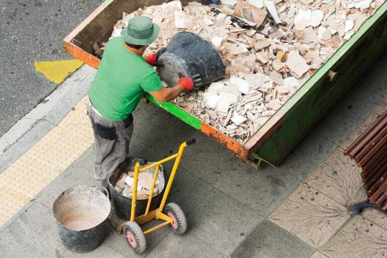 Baumaterial fürs Recycling: Bauarbeiter kippt Schutt aus