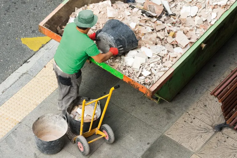 Baumaterial f&uuml;rs Recycling: Bauarbeiter kippt Schutt aus