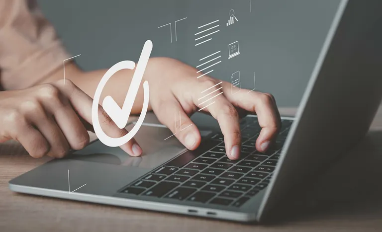 Hand tippt auf Laptop.