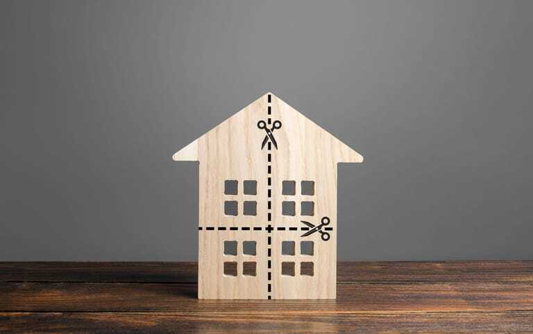 Bauklotzhaus auf dem Scheren-Linien aufgemalt sind. Symbolbild Teilverkauf.