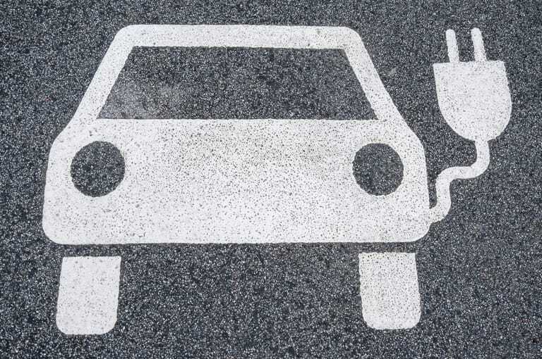 Weißes E-Auto-Symbol auf Parkplatz