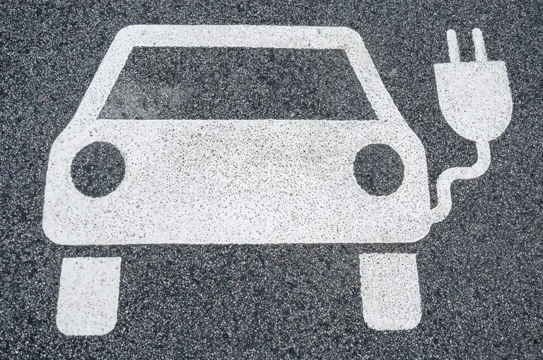 Weißes E-Auto-Symbol auf Parkplatz